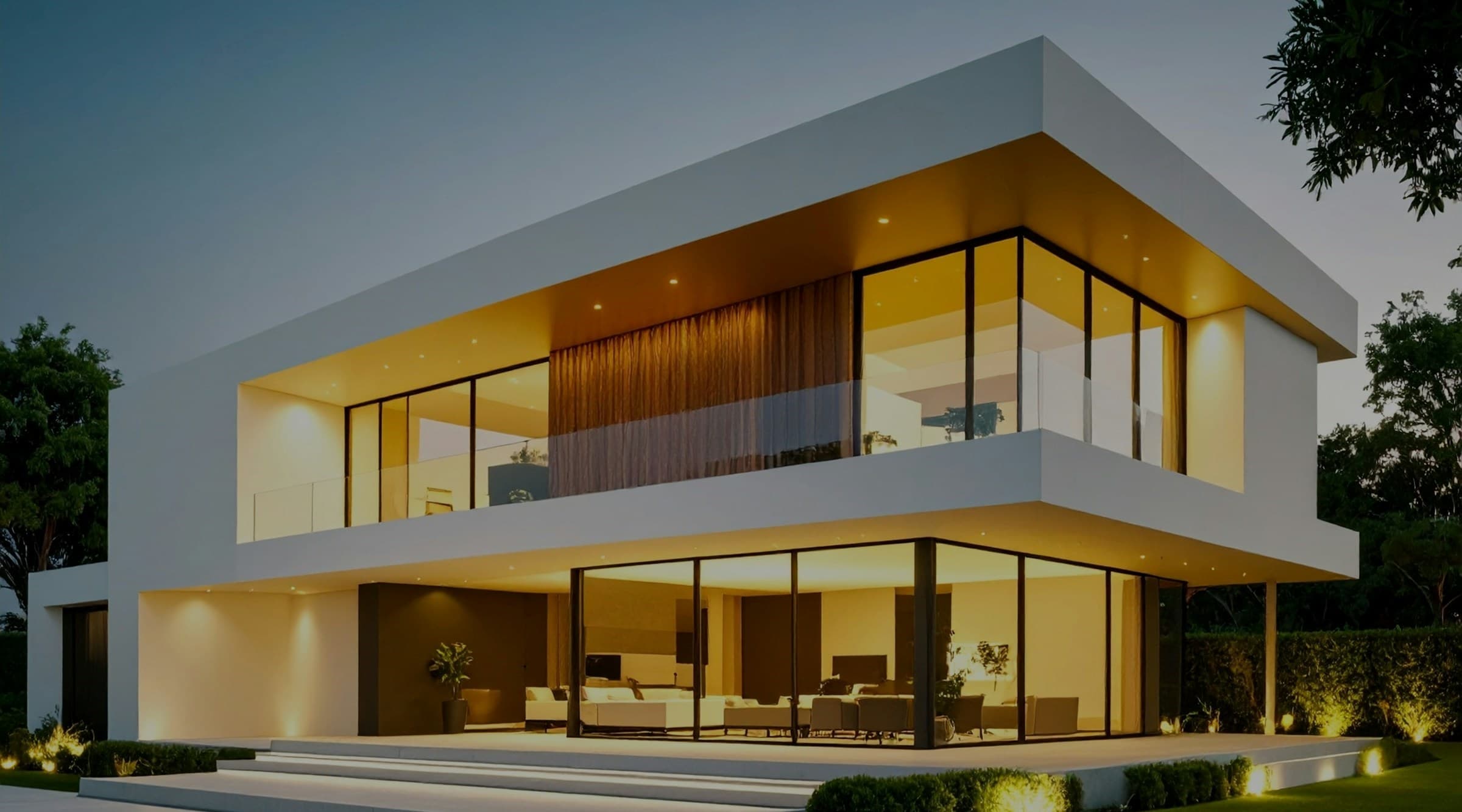 Modern white home exterior with glowing glass walls at dusk